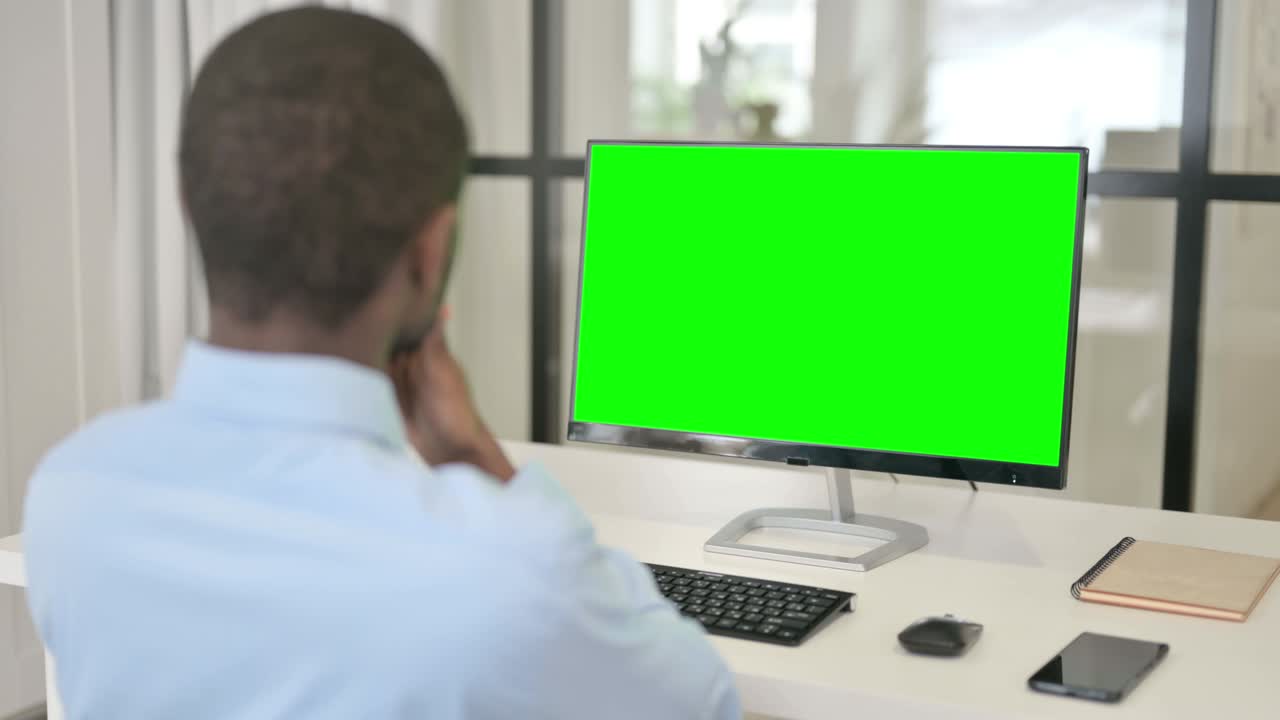 hombre de negocios mirando el escritorio con pantalla clave de croma verde