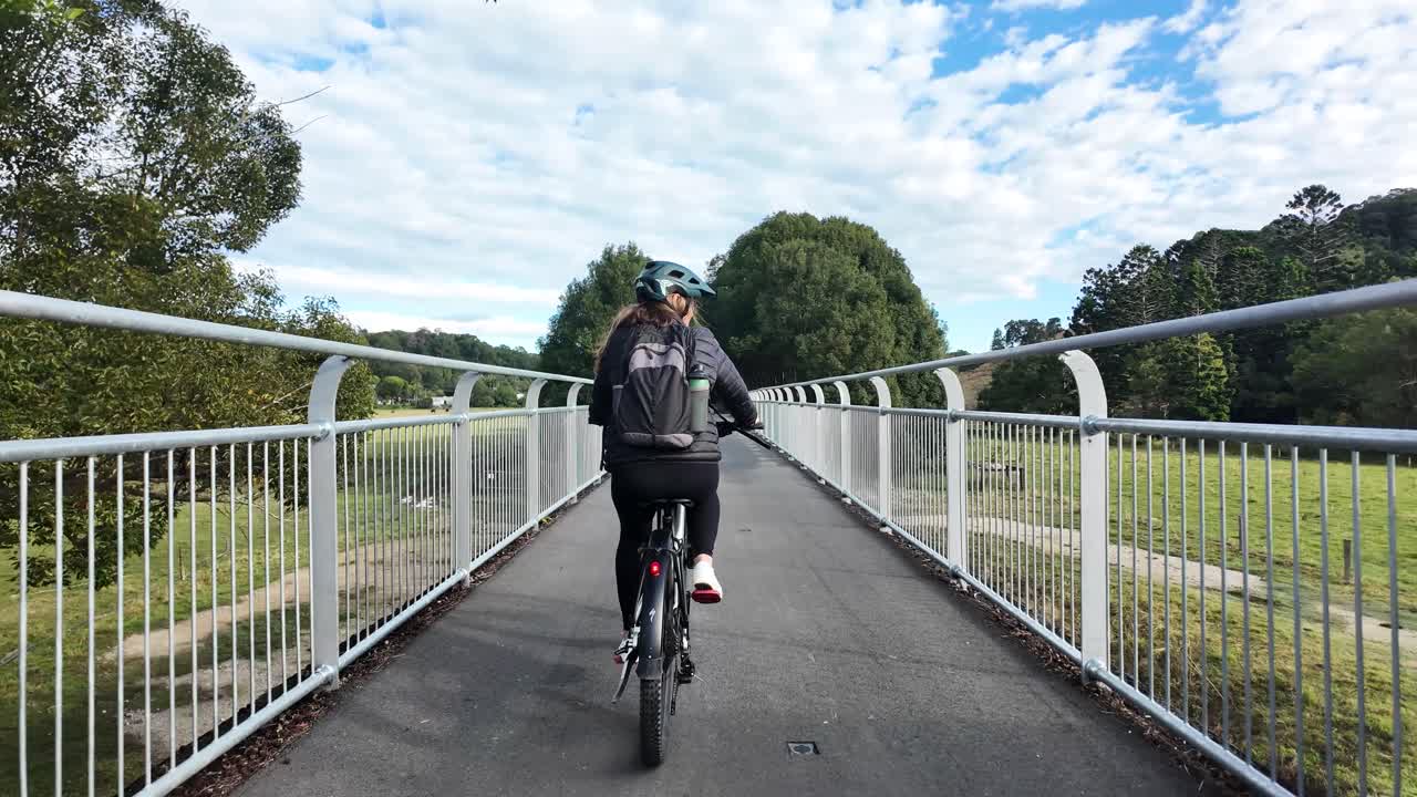 A person riding a bicycle across a scenic bridge