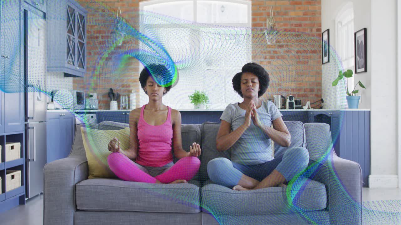 Mom and daughter starting meditation on gray sofa, moving arms while colorful wave overlapping them
