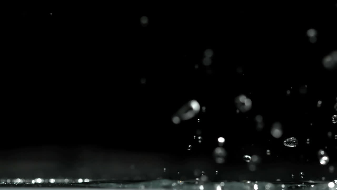 Toy car rolling over water and splashing on black background