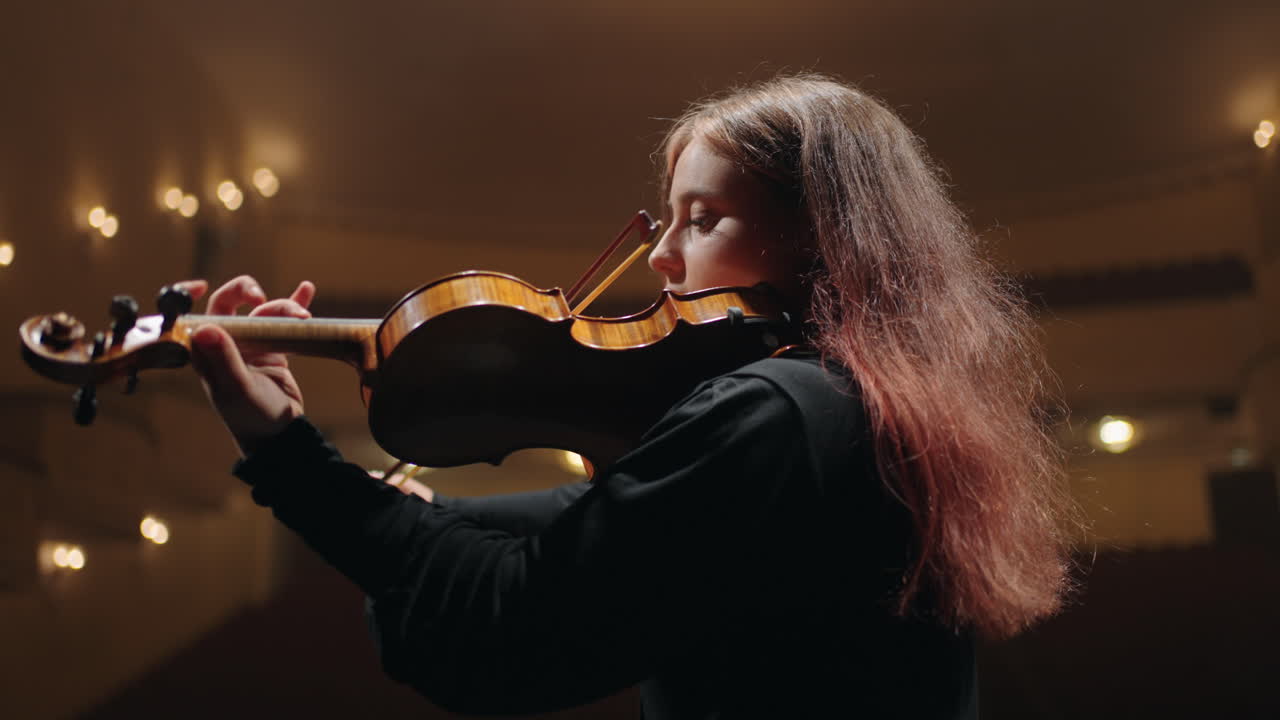 una violinista en una ópera moderna una violinista está tocando el violín en una sala de música