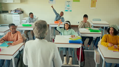 students raising hands in a classroom
