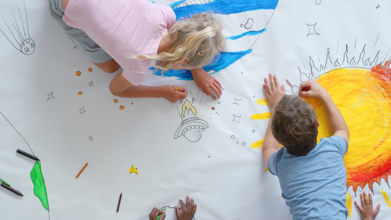 Children Collaborating on a Large Space-Themed Drawing