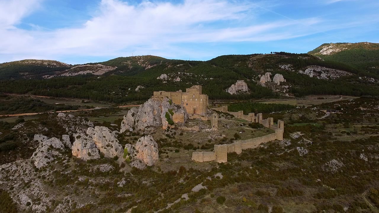 Il Castello di Loarre con sfondo montuoso nella provincia di Huesca, Aragona, Spagna. Ripresa aerea con allontanamento