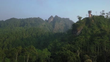 Aerial-view-of-forest-and-hills-with-fog-between-in-the-morning-in-Indonesia