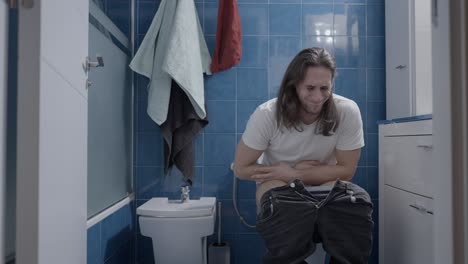 man experiencing digestive issues in bathroom