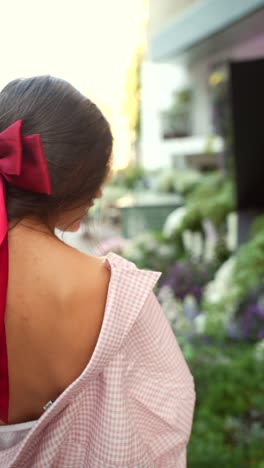 woman with red bow and pink shirt outdoors