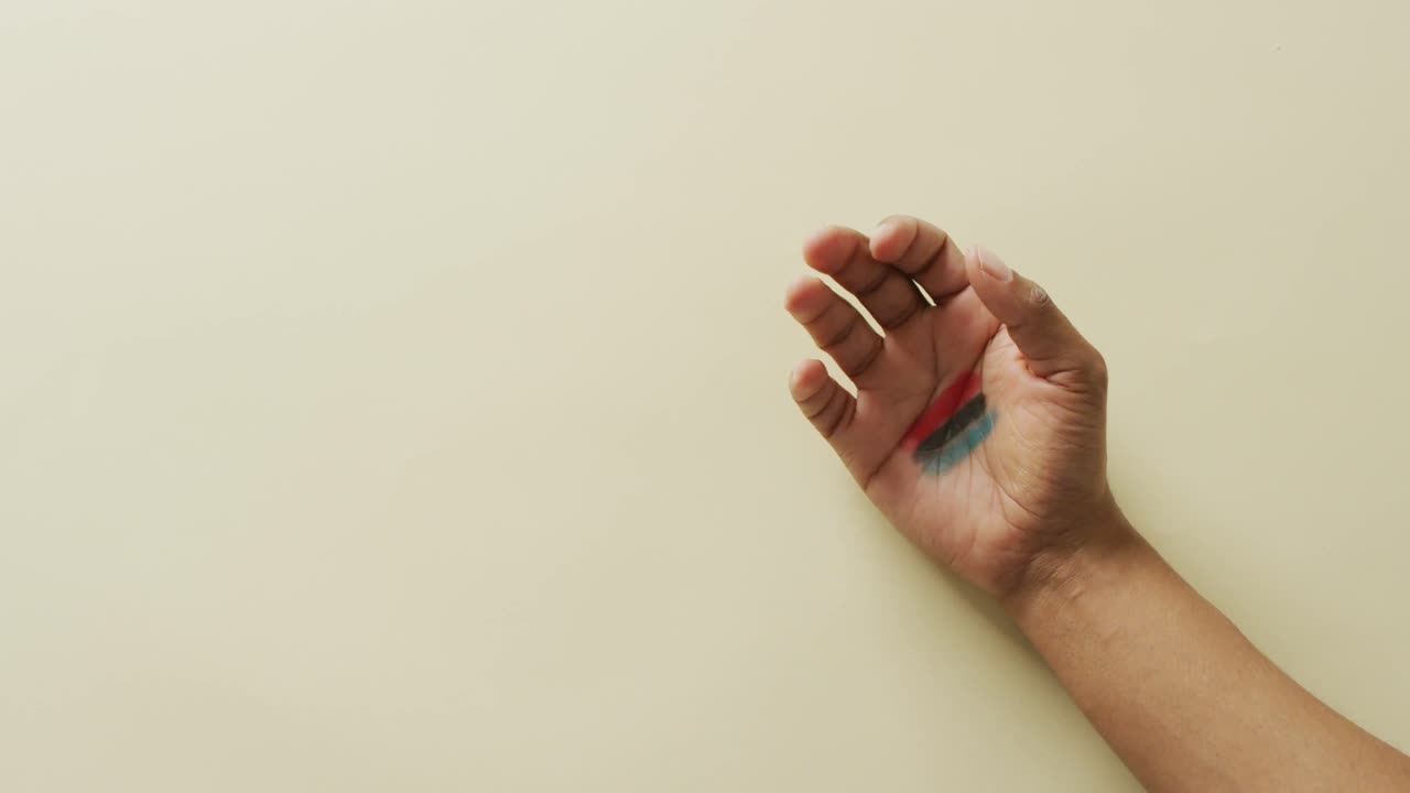 video de las manos de una mujer afroamericana abriendo la mano con la bandera de la unión africana