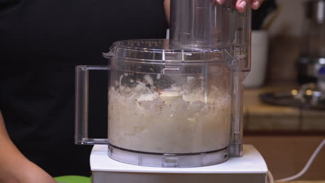 chopping organic onions in the food processor as an ingredient for a homemade, vegetarian recipe