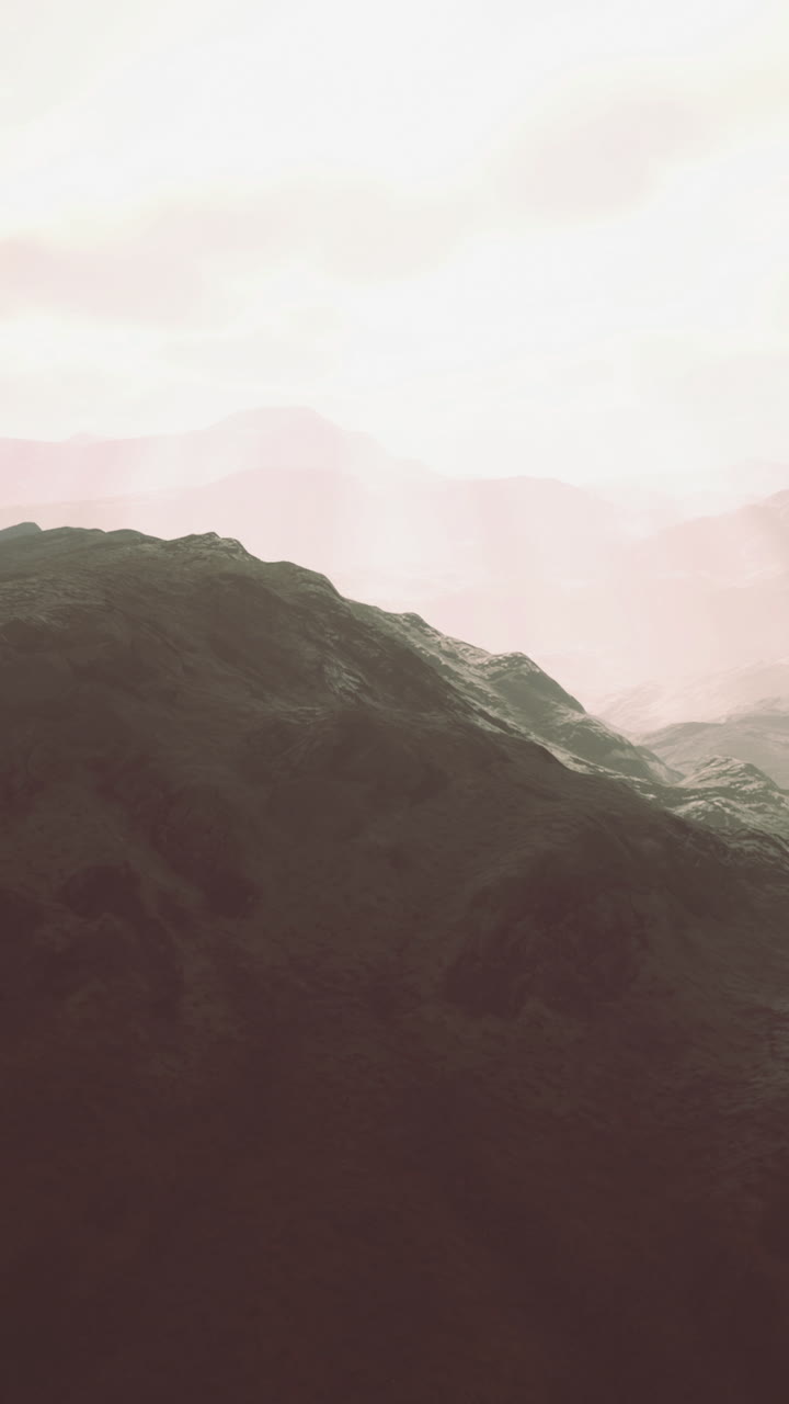 Misty mountain peaks bathed in golden sunlight during early morning hours