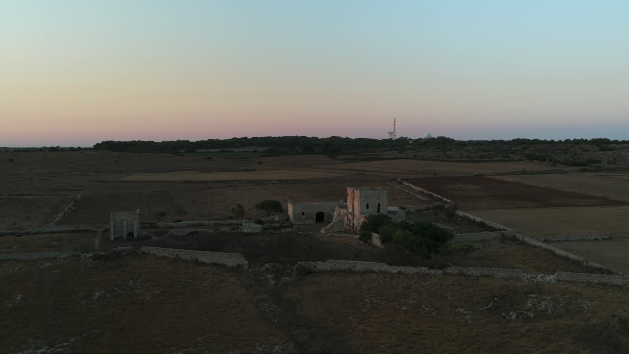 Masseria Cippano che mostra un'antica casa colonica nel paesaggio rurale italiano al crepuscolo
