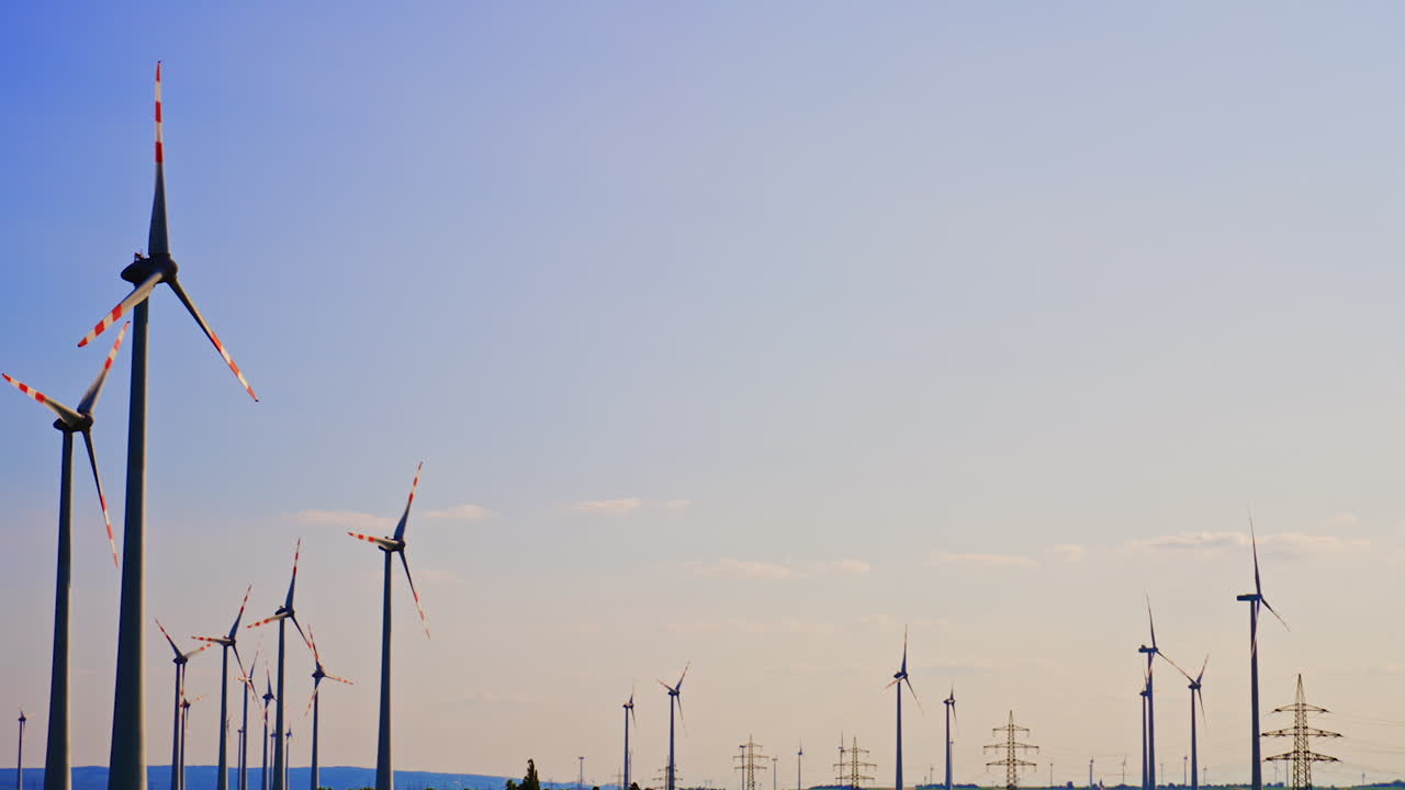 Sunset wind turbines producing energy. Wind turbines stand tall against a clear sky, harnessing wind energy during sunset near a peaceful landscape