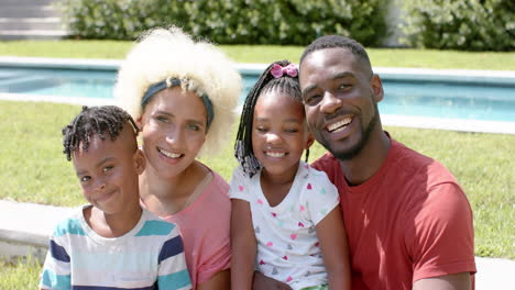 familia afroamericana con una joven mujer biracial sonríe juntos al aire libre en casa