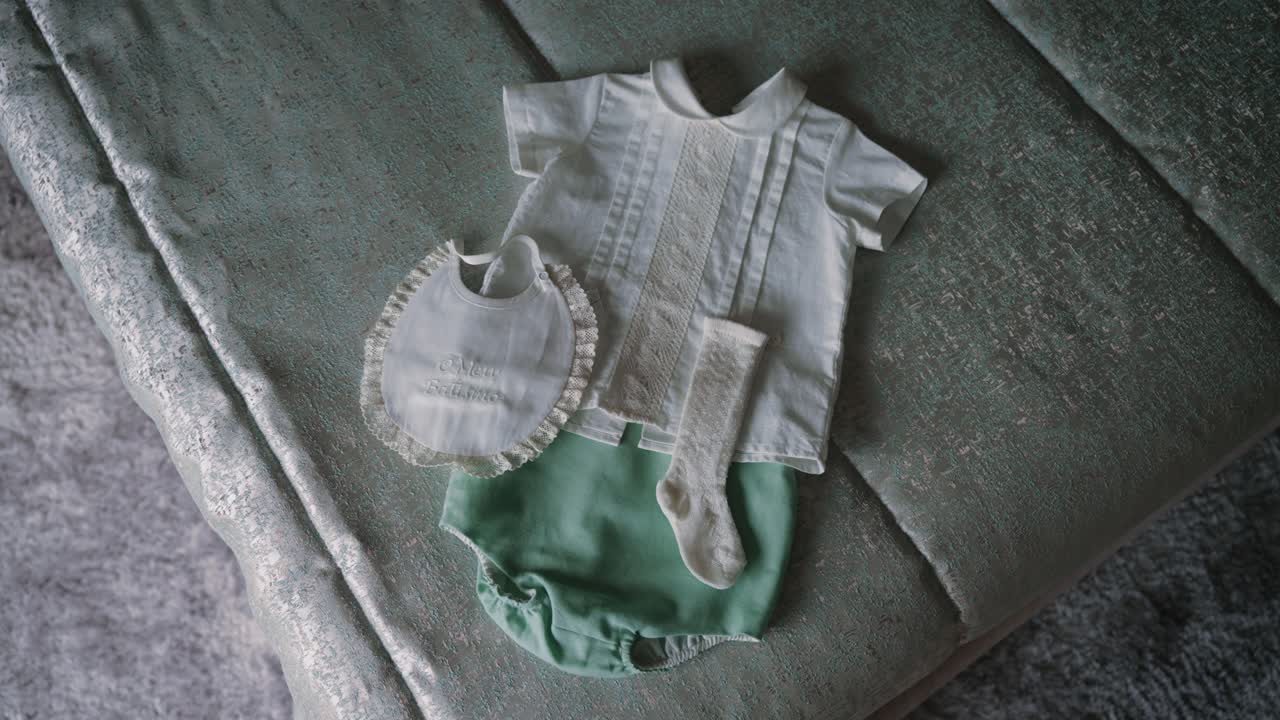 christening clothes laid out with mint bloomers white bib lace socks and pleated shirt