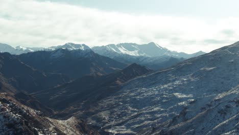 aerial reveal of huge snow covered mountain range, queenstown new zealand