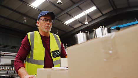 Worker-moving-trolley-of-cardboard-boxes