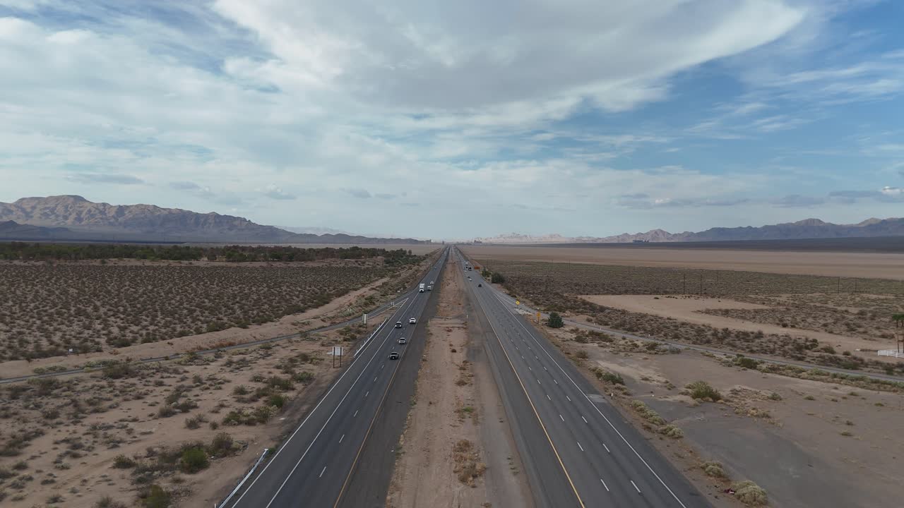 Aerial view on Interstate 15, Barstow Freeway, Nipton California, little traffic on highway, mountains and overcast skies in the distance, Mojave Desert