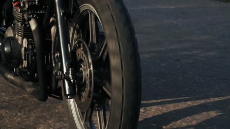 Close-Up-view-of-a-moving-firewheel-of-the-motorcycle.-Unrecognizable-person-riding-the-motorcycle-on-a-country-road