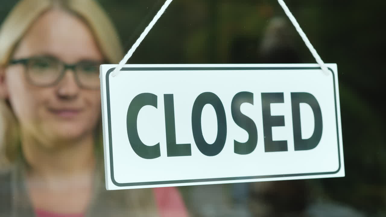 la vendedora gira la tableta que dice cerrado para abrir el comienzo del día abre tu negocio