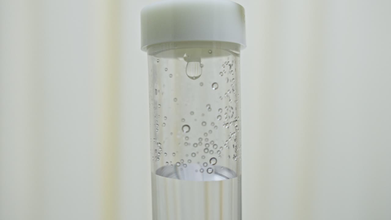Primo piano di una flebo che gocciola da una linea di infusione medica.