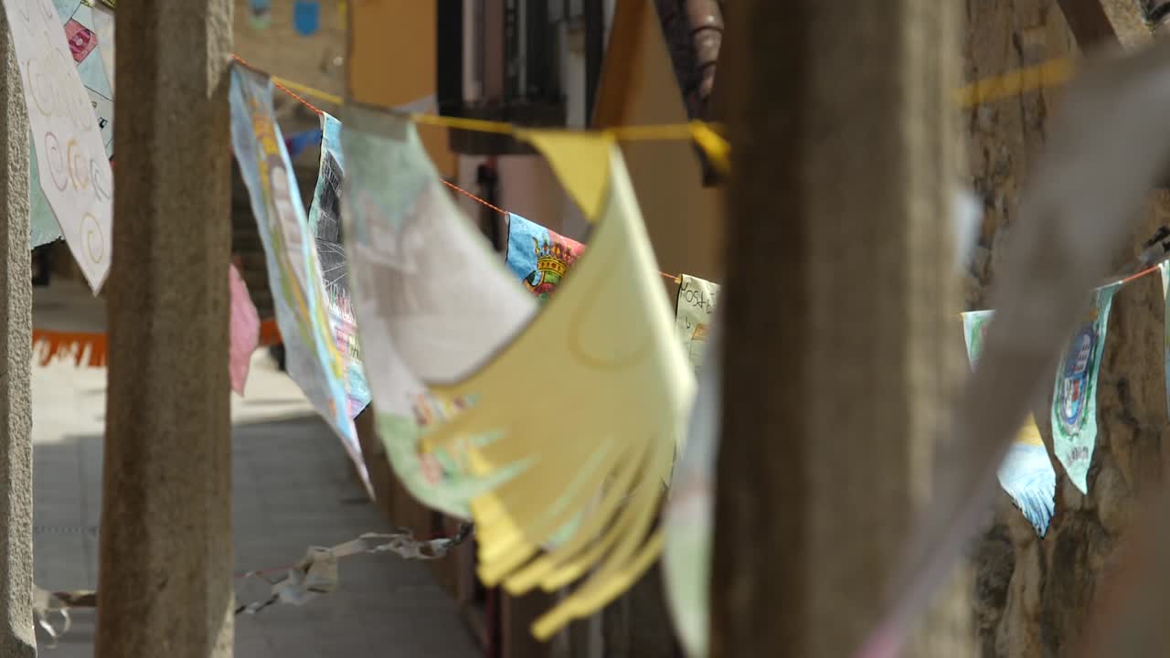 Handmade party flags hanging in the old town streets at the jacobs way in Santa Maria de Oia in slow motion