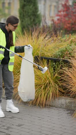 mujer limpiando la basura en un parque de la ciudad