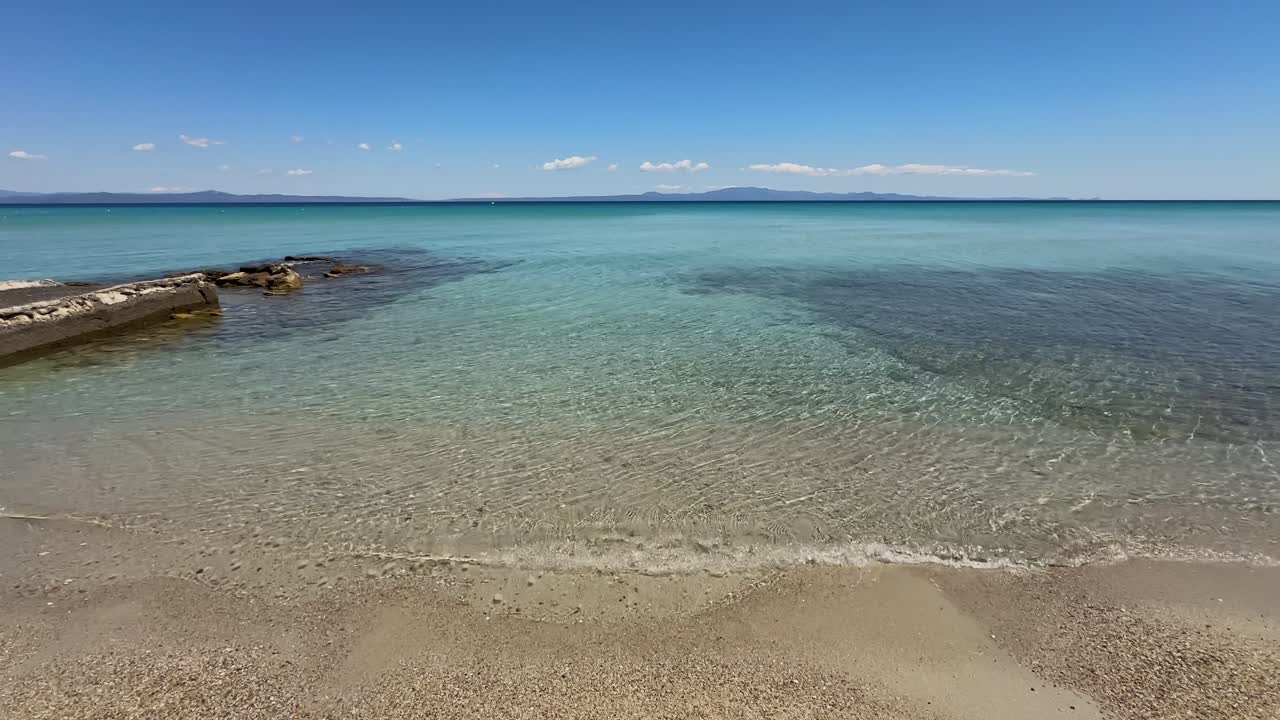 Stunning beach scene in Halkidiki, Greece, with elegant sunbeds facing the crystal-clear turquoise sea. A perfect summer escape in the heart of the Aegean.