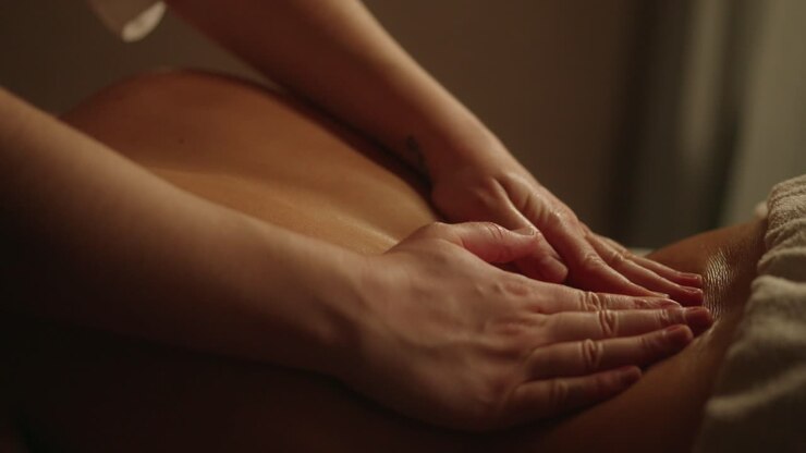 Professional Back Massage Hands in dimly lit room