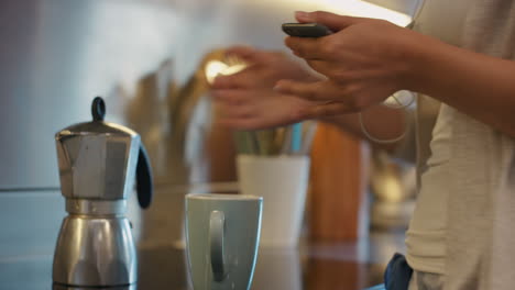 Schöne-Frau,-Die-Morgens-Mit-Smartphone-Technologie-Kaffee-Kocht