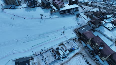 a panoramic view of a snowy village, with houses and streets blanketed in fresh snow, creating a picturesque winter scene