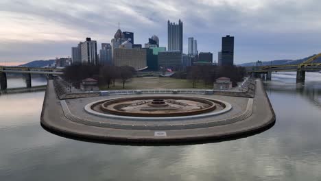 Aerial-pullback-reveal-of-converge-of-Allegheny-and-Monongahela-Rivers-in-the-Ohio-river-at-Point-State-Park-in-Pittsburgh,-Pennsylvania