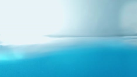 la superficie del agua limpia en cámara lenta llena la pantalla con agua salpicando la gota de agua y la superficie líquida ondeando con una burbuja de aire