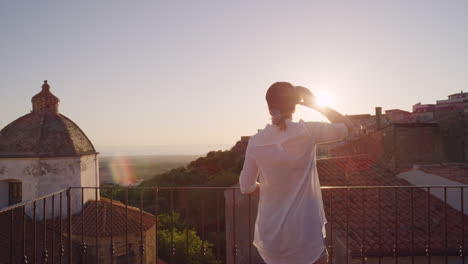 Frau,-Die-Auf-Dem-Balkon-Ein-Virtual-Reality-Headset-Verwendet-Und-Sich-Umschaut,-Genießt-Die-Erfahrung,-Den-Online-Cyberspace-Vor-Wunderschönem-Sonnenuntergangshintergrund-Zu-Erkunden