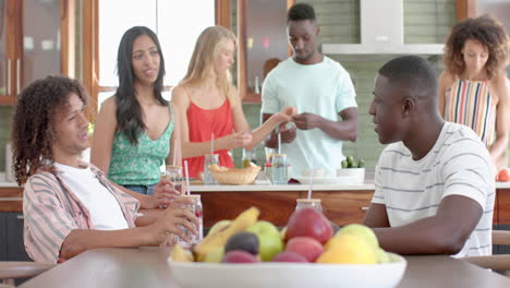 un grupo diverso de amigos se reúnen en una cocina doméstica