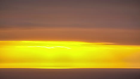 timelapse of sunset behind the clouds over the sea