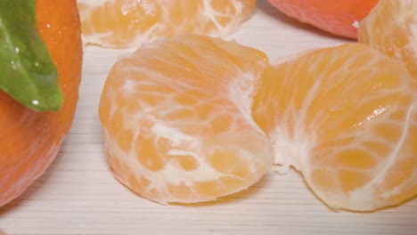 close up macro shot revealing 2 segments of a mandarin orange on a table, a fresh healthy citrus fruit filled with vitamins, nutrients and minerals