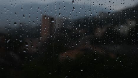 Gota-De-Lluvia-Cayendo-A-Través-De-Un-Cristal-De-Ventana