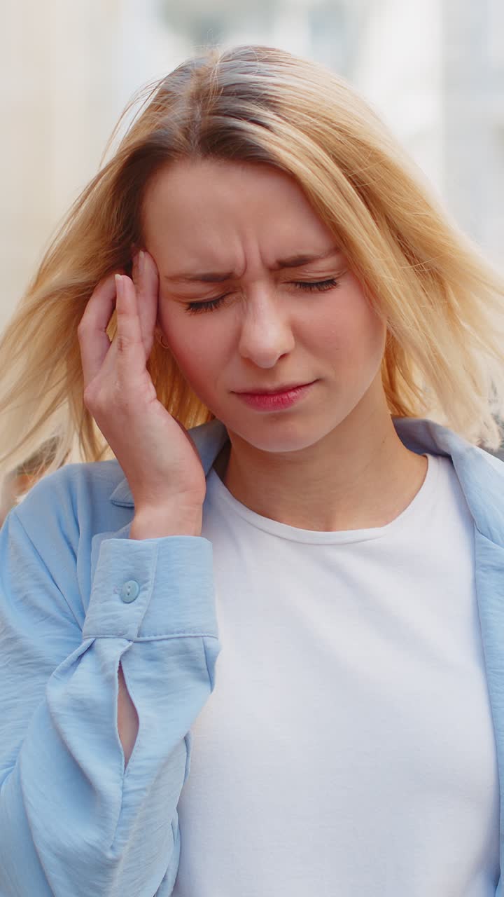 Donna insoddisfatta e esausta che si frega le tempie per curare il problema del mal di testa che soffre di emicrania da tensione