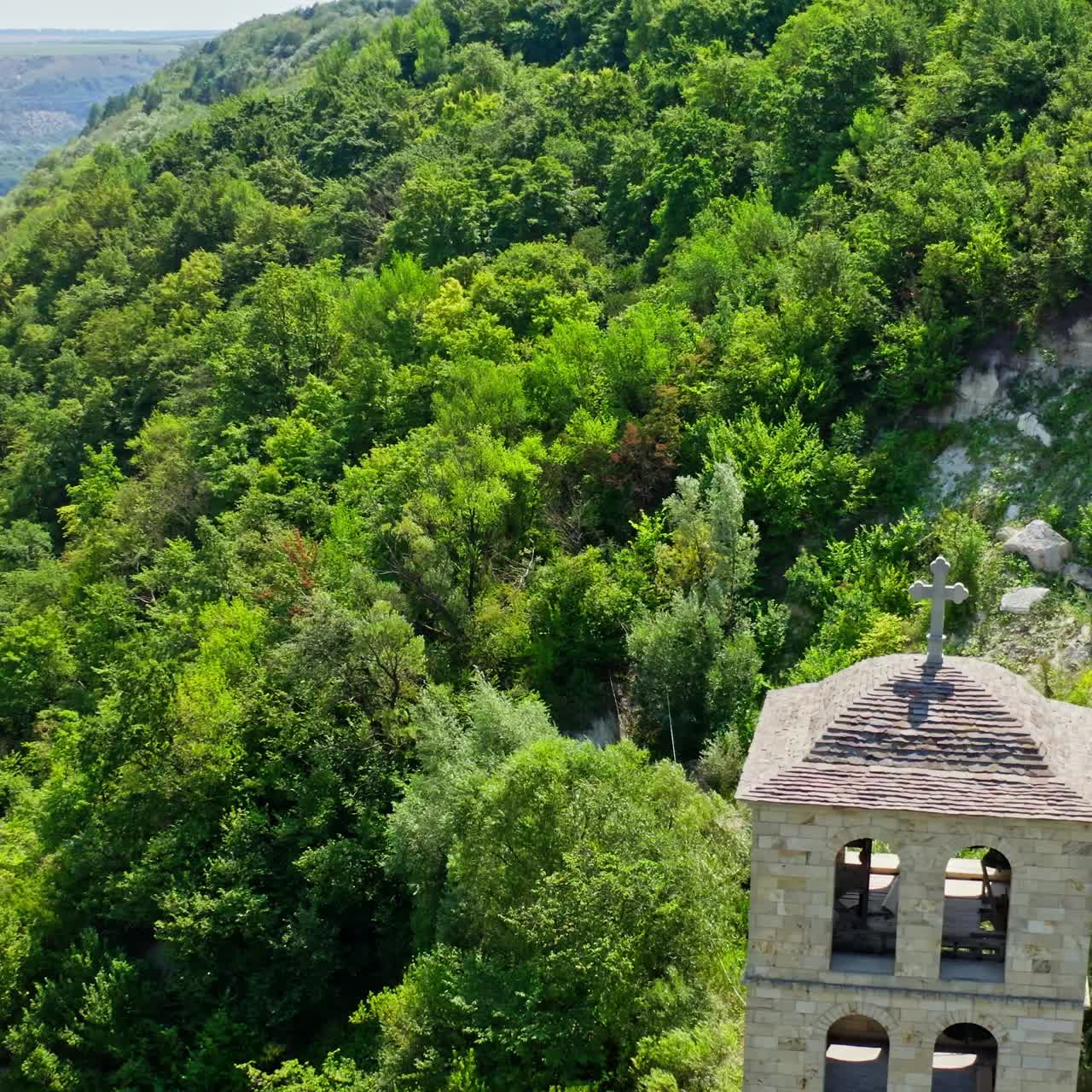 Stone building surrounded with nature. Unfinished church in the mountains. Tall architecture on the hill in summer. Motion camera around.