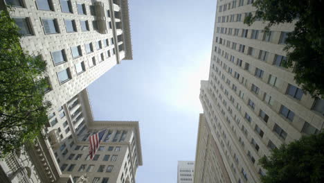 in downtown los angeles california usa, a collection of european-style buildings stands alongside towering skyscrapers, with us flag banners visible as the camera pans