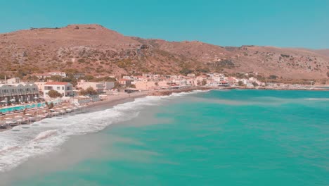 Drone-flying-past-a-small-Greek-town-with-mountain-in-background