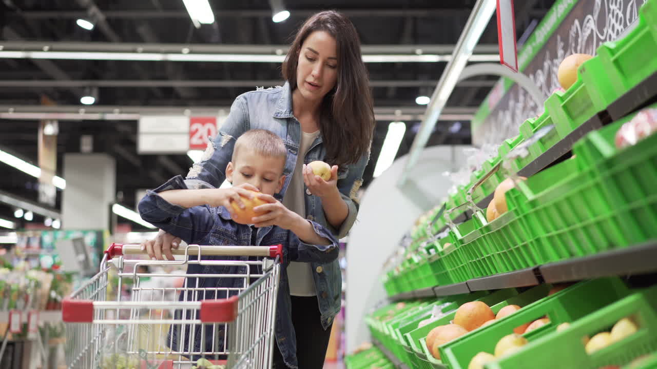 Mother and son shopping for fruit at the grocery store
