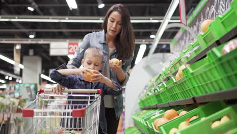 mother and son shopping for fruit at the grocery store