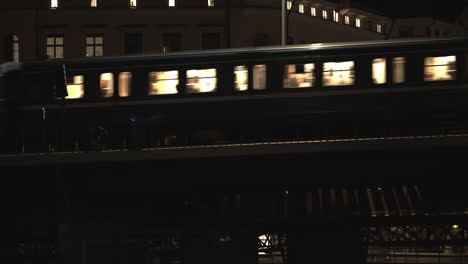 tilt from river to passing subway in stockholm sweden at night