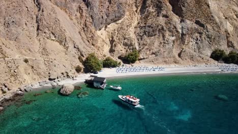 vue plongeante sur les touristes débarquant d'un bateau sur la plage d'eau douce de glyka nera, dans le sud de la crète, en grèce