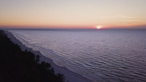 Drone-footage-of-a-sunset-over-Baltic-Sea,-Lubiatowo-Beach,-Poland