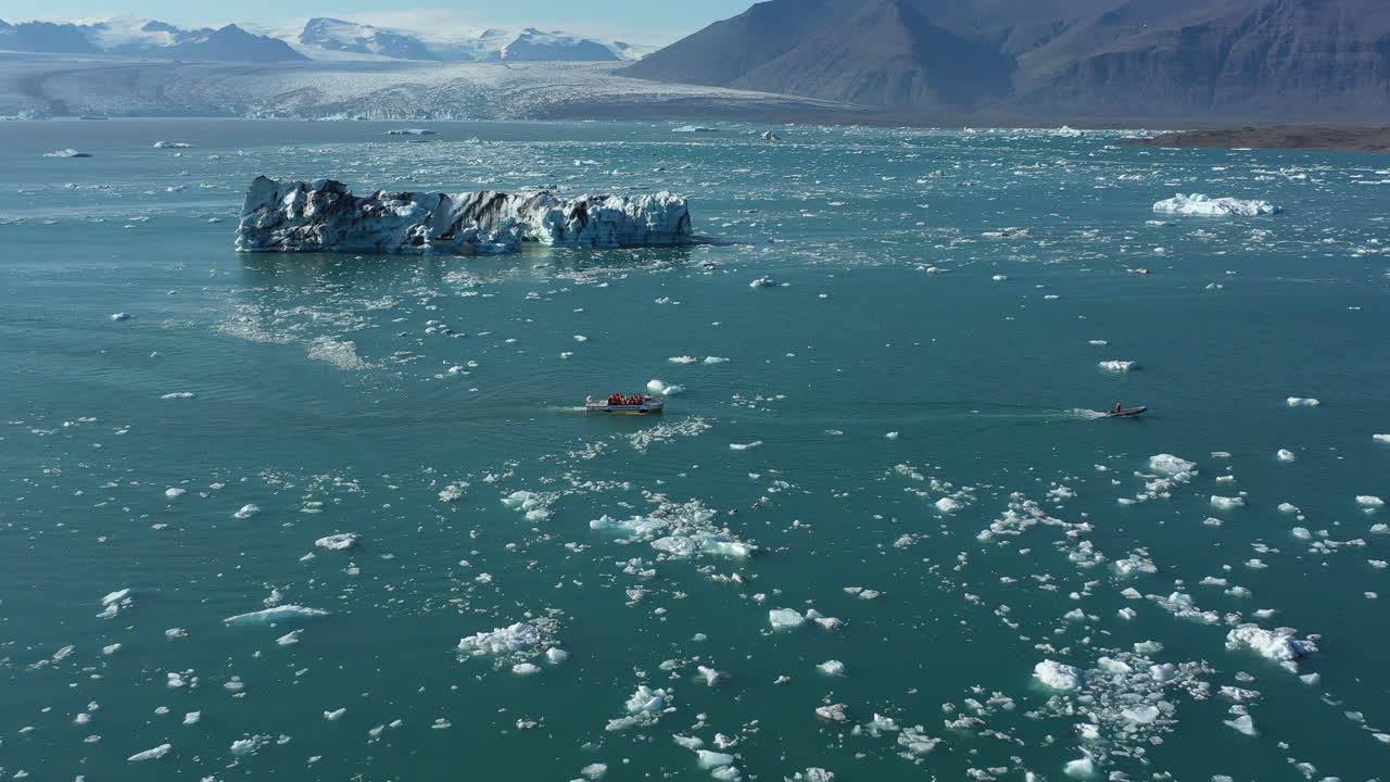 Icebergs and boats on Jökulsárlón glacier lagoon in Iceland