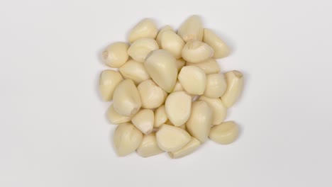 garlic cloves on white. top view. loop motion. rotation 360.