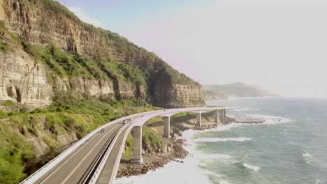 seaside scenic drive, sea cliff bridge by hazy ocean aerial view, australia