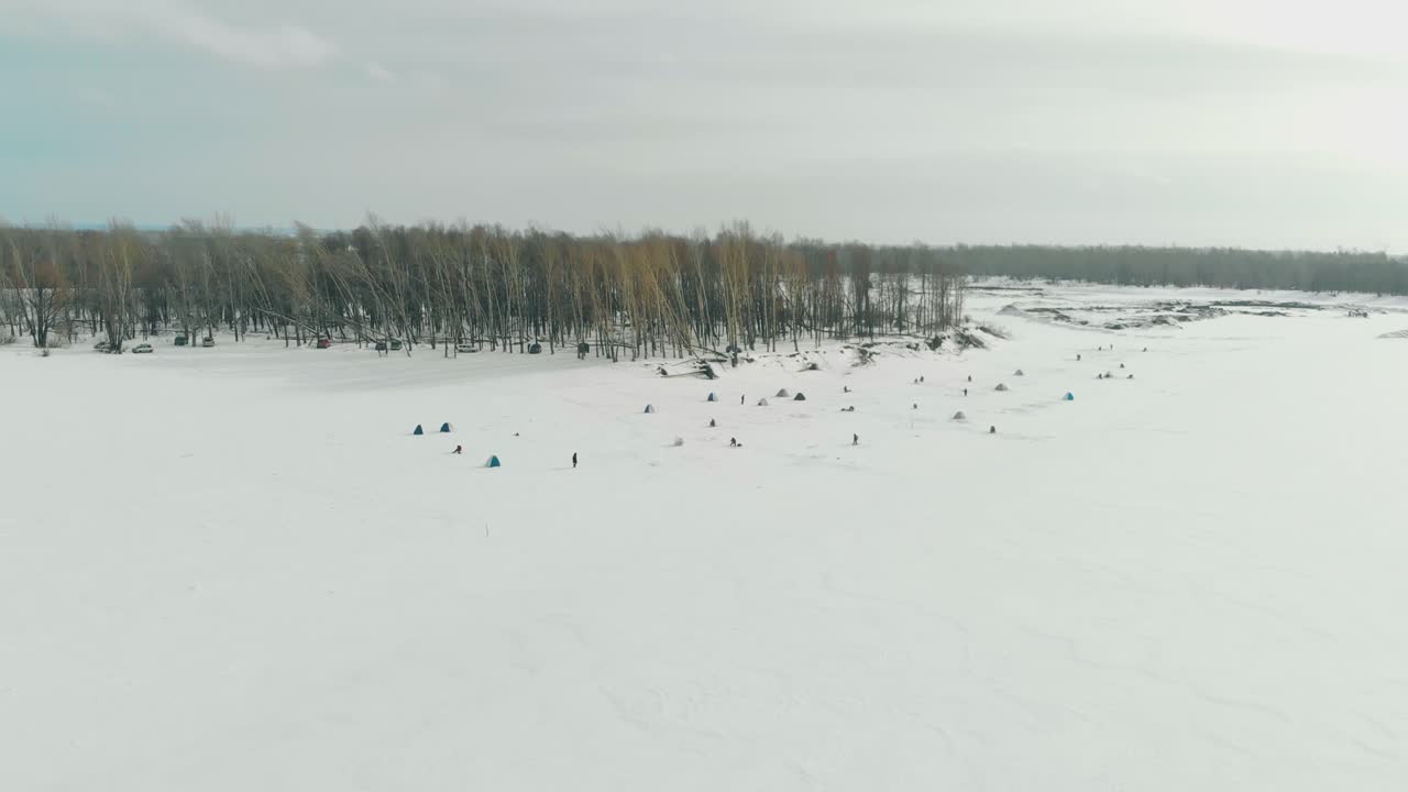 어부들은 하얗게 얼어붙은 강 표면의 얼음 위에 정착한다